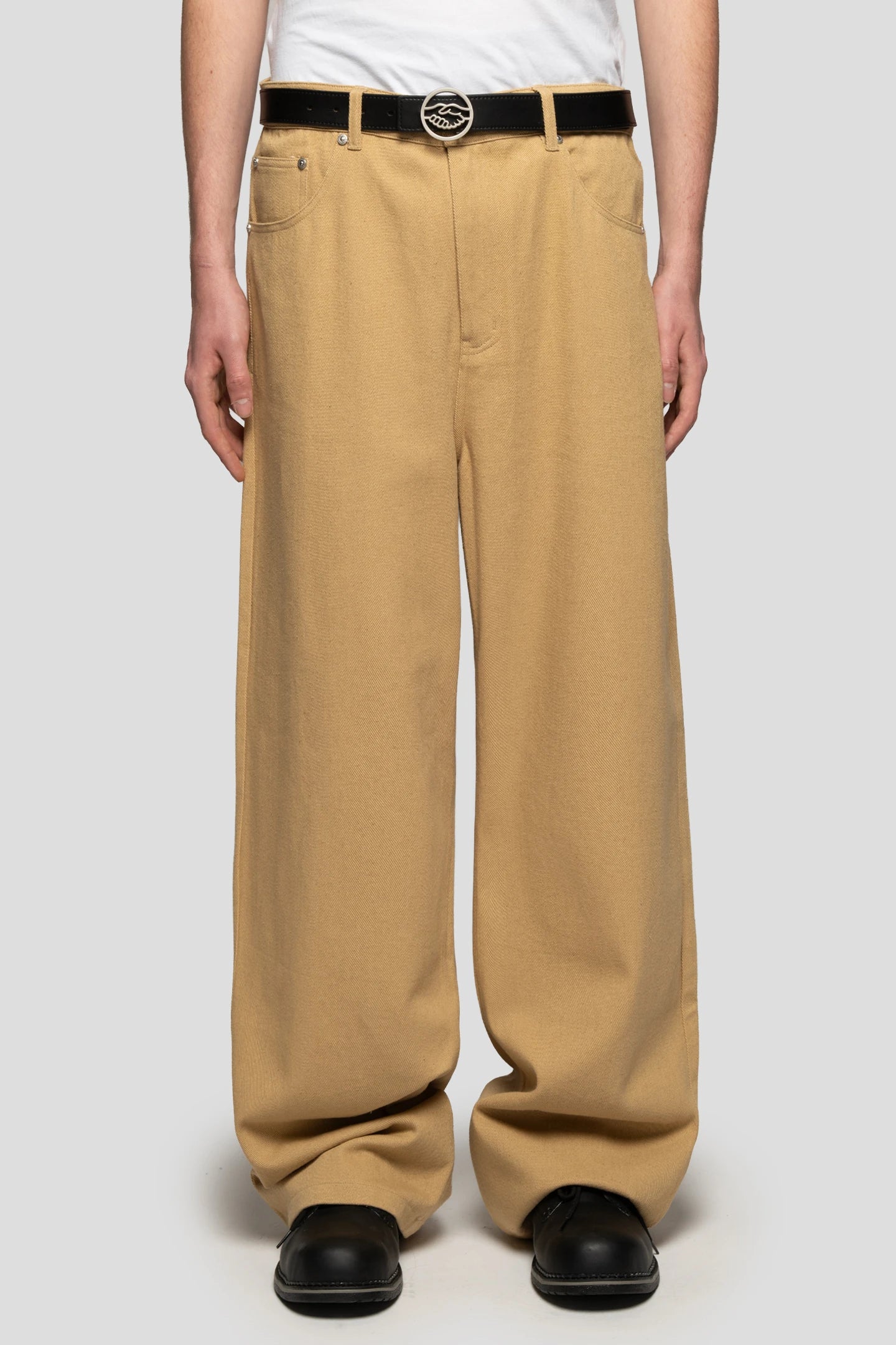 Model wearing beige baggy jeans with Marten's boots by 93 sierra crosses