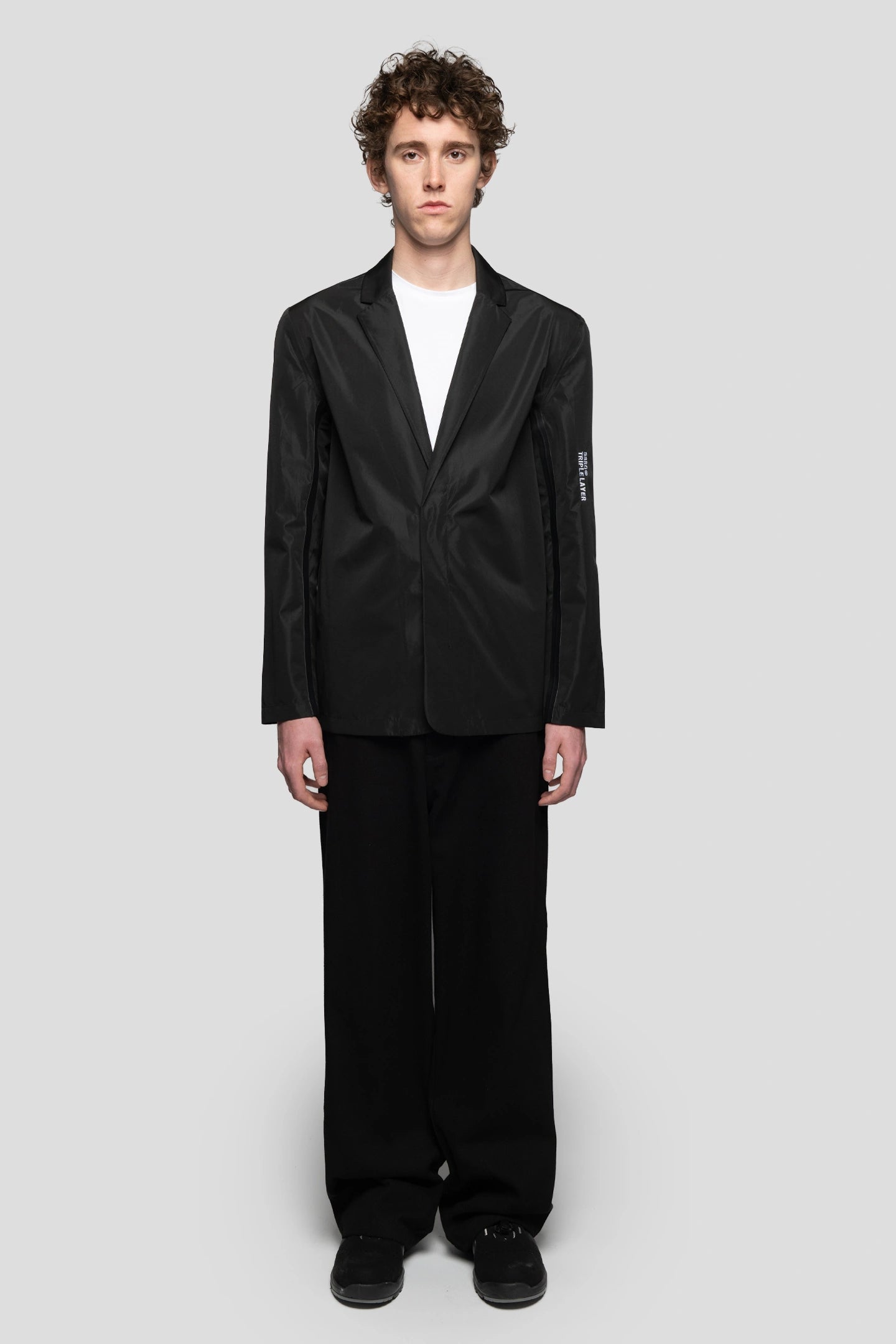 Model wearing black waterproof blazer with triple layer technology developed by 93 sierra crosses