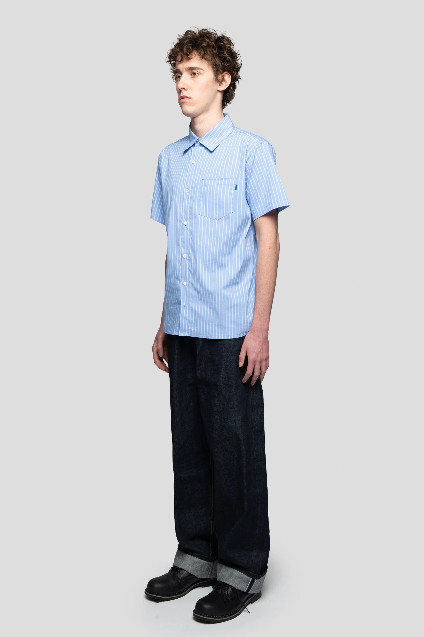 Modelo vistiendo una camisa de manga corta de rayas estilo skater