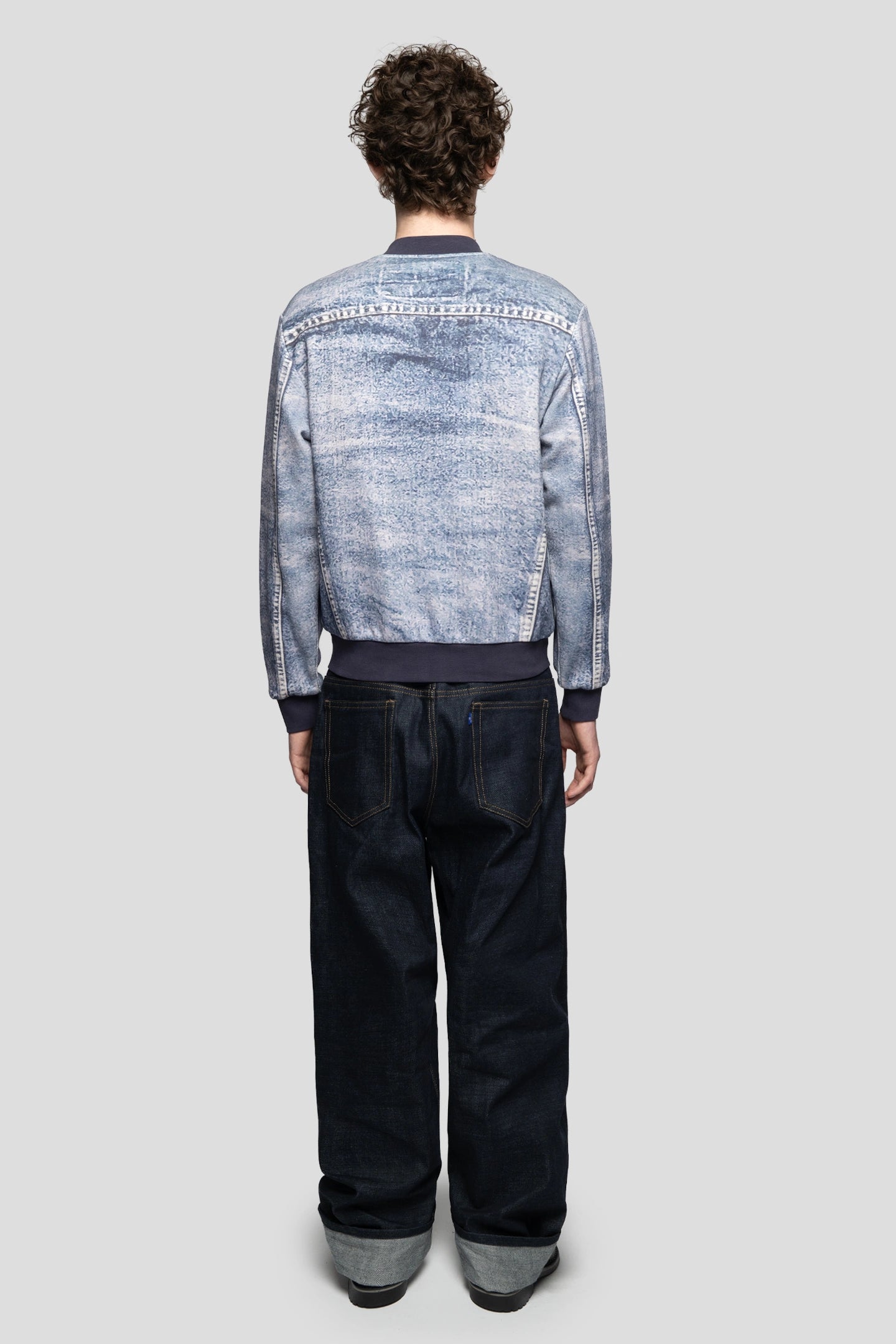 Back view of model wearing fake denim jacket with jeans all made by 93 sierra crosses