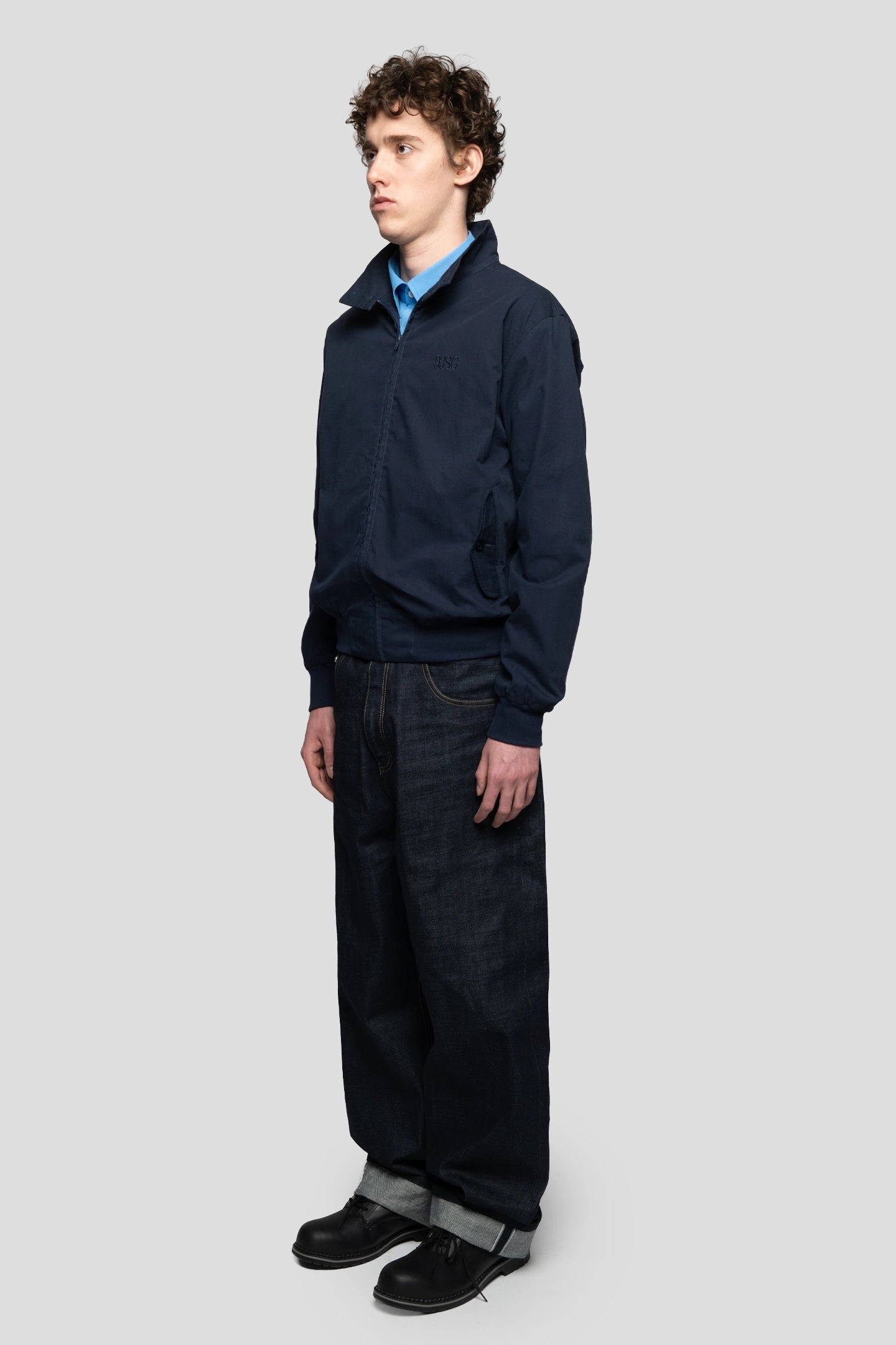Model wearing a harrington jacket with baggy jeans and boots