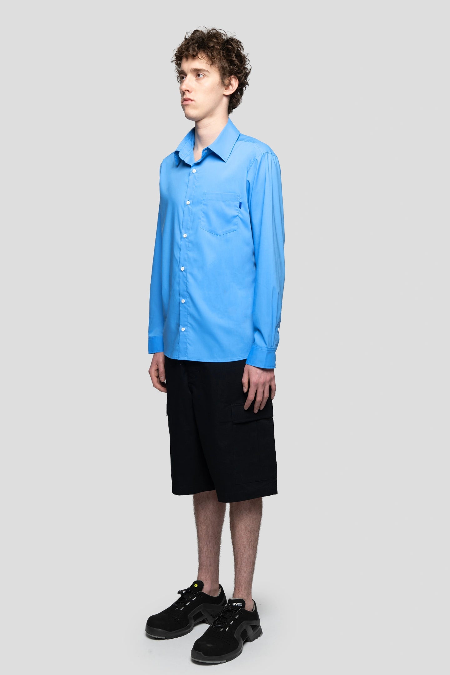 Model wearing office blue shirt regular fit with cargo shorts and working boots 93 sierra crosses