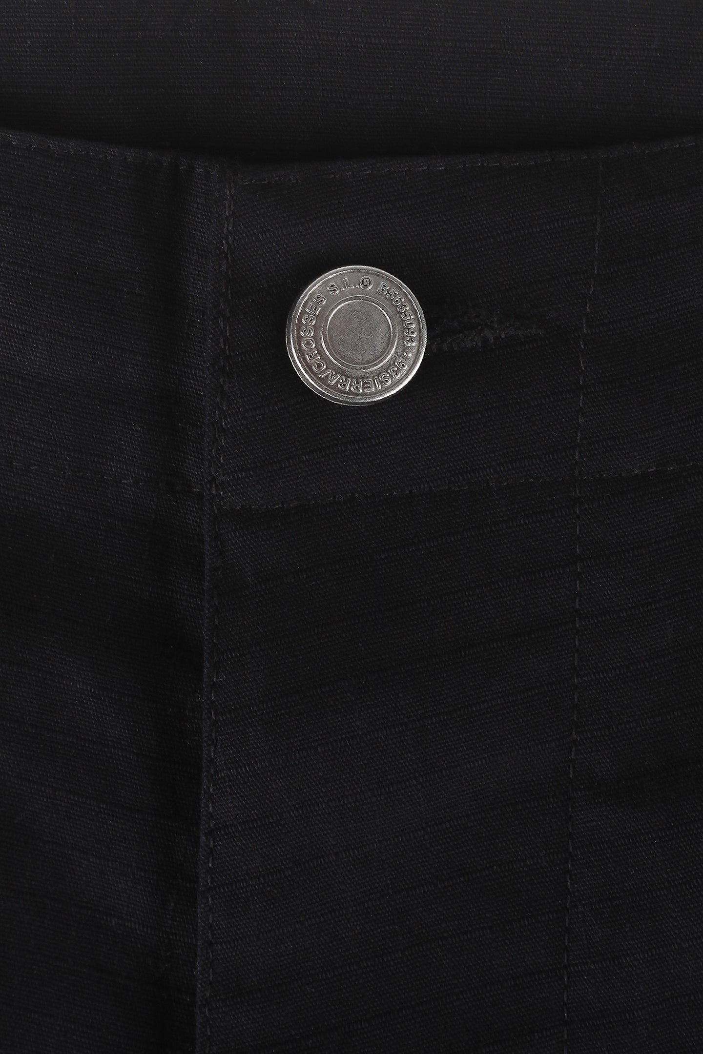 Signature silver shiny button brand on black workwear pants close view 93 sierra crosses