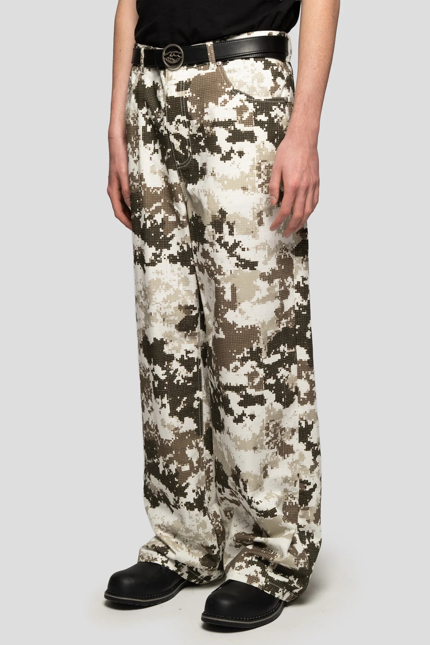 diagonal view of model wearing baggy digital camo trousers in black and white tones, relaxed streetwear fit by 93 Sierra Crosses

