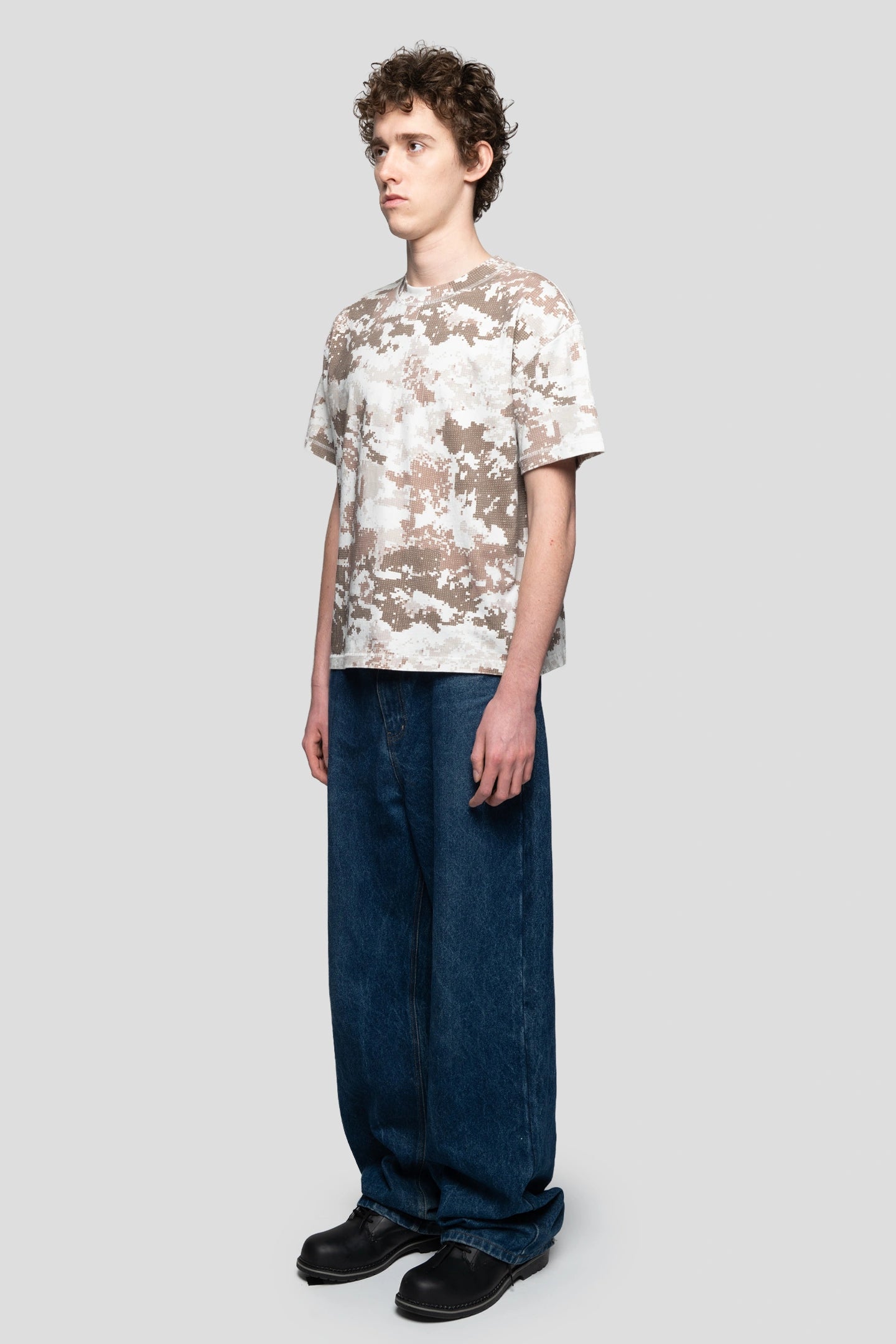 Model wearing the digital camo t-shirt in brown of the new collection of 93 sierra crosses relaxed pose looking diagonal