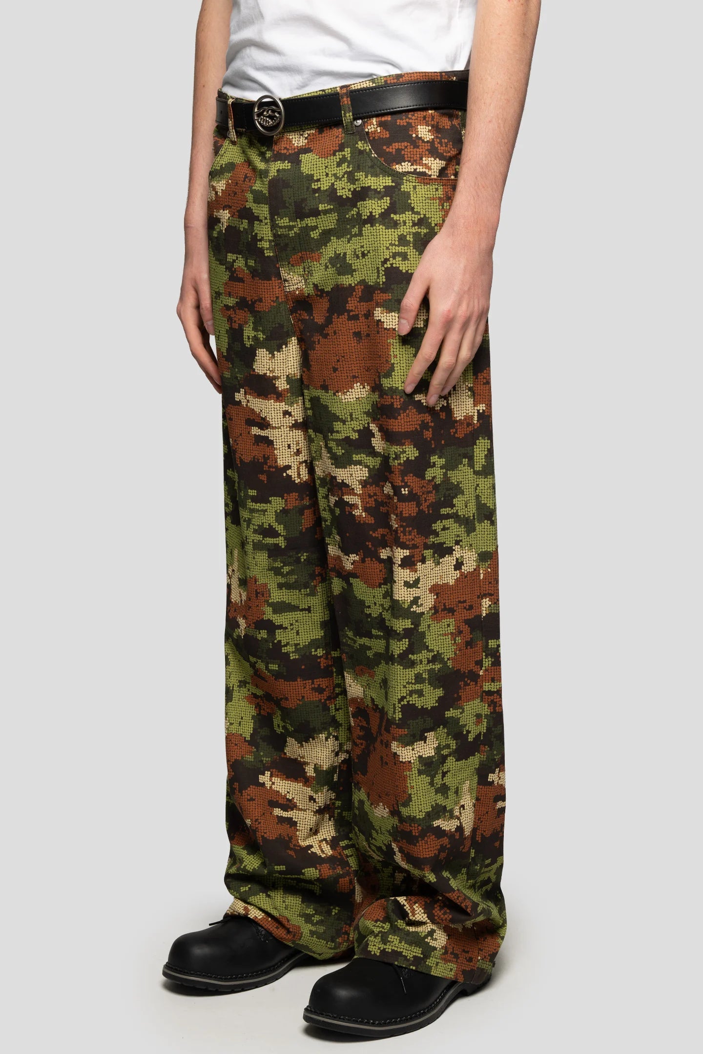 Diagonal view of model wearing militar digital camo trousers by 93 sierra crosses