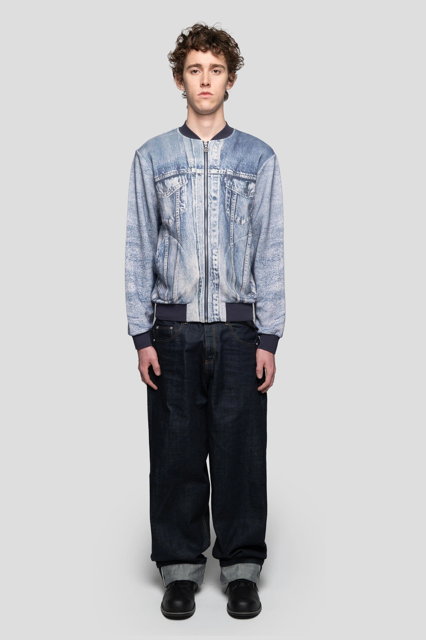 Front view of model wearing printed denim fleece bomber jacket and heavy cotton jeans by 93 sierra crosses